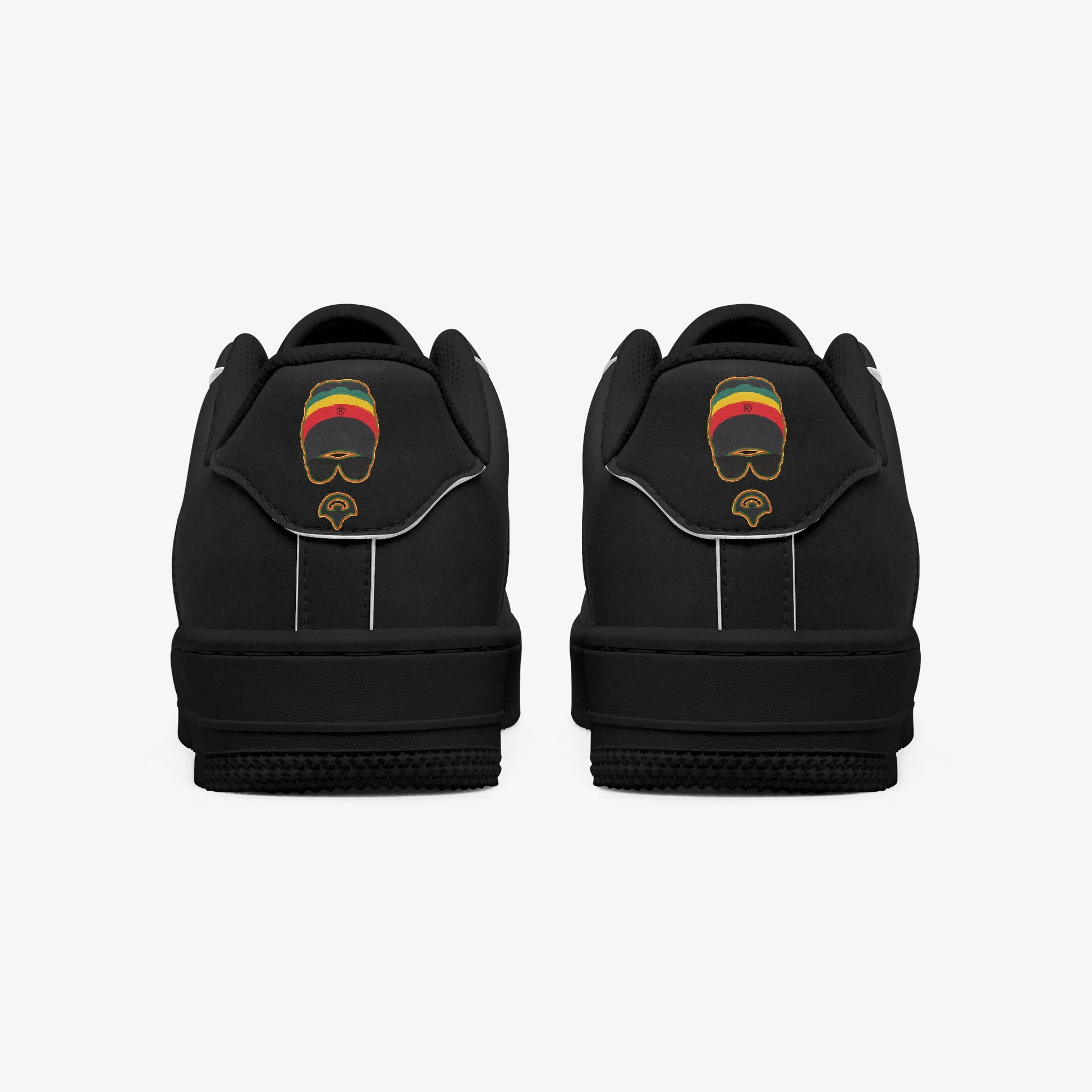 A pair of black low-top leather sneakers with breathable mesh lining and bold red accents, displayed against a backdrop featuring the words 'Freedom Walks In' in glowing neon. The design honors Juneteenth with subtle Pan-African color details and a powerful streetwear aesthetic that blends heritage and modern style.